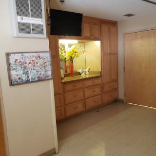 A spacious interior featuring wooden cabinetry, a mounted television, and decorative artwork.