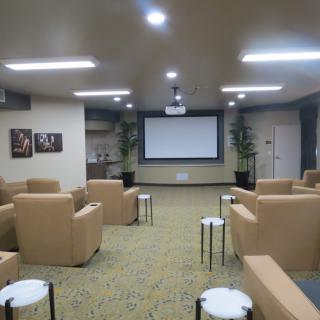 A cozy home theater with comfortable seating and a large screen for viewing.