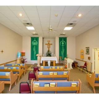 Interior view of a small church with pews and an altar.