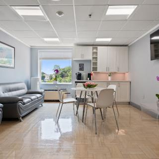 A modern and bright living space featuring a cozy sofa and a dining area.
