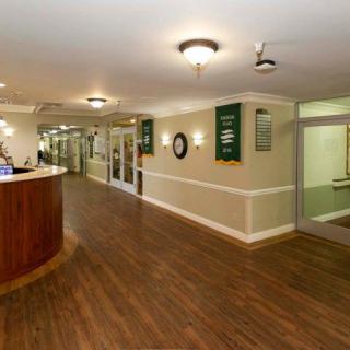 A spacious reception area with wooden flooring and ambient lighting.