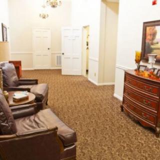 A cozy living room area with comfortable chairs and decorative elements leading to a hallway.