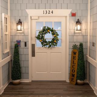 A welcoming entrance with a decorative wreath and plants.