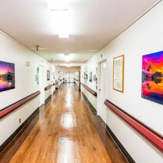 A brightly lit hospital hallway adorned with colorful artwork on the walls.