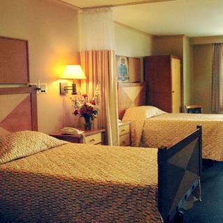 A cozy hotel room featuring twin beds and warm lighting.