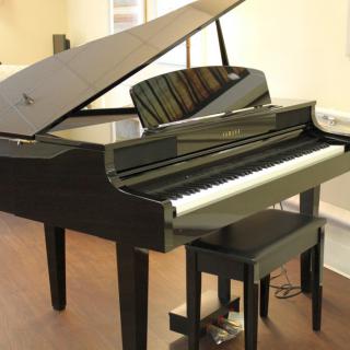 A black grand piano in a music room setting.