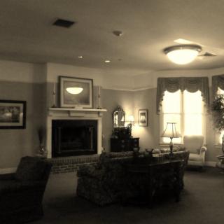 A vintage-style living room with a fireplace, comfortable seating, and soft lighting.