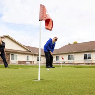 Two individuals enjoying a game of golf on a sunny day.