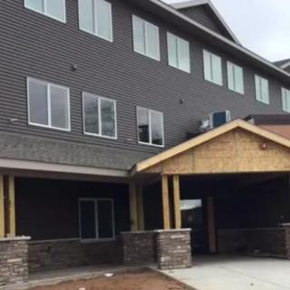 A modern building under construction with multiple windows and an entrance canopy.