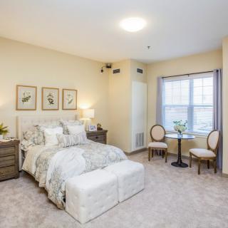 A cozy bedroom with a large bed, side tables, and decorative artwork on the walls.