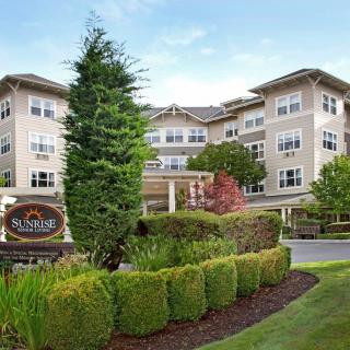 A picturesque view of a hotel surrounded by lush greenery and well-maintained hedges.