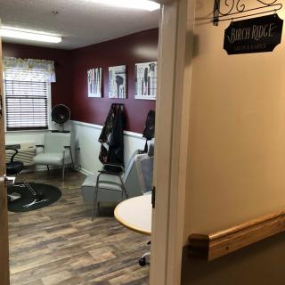 A cozy hair salon with chairs and mirrors, ready for customers.
