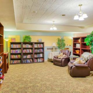 A cozy library reading area with bookshelves and comfortable armchairs.