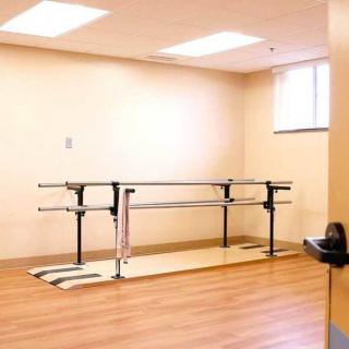 A physical therapy room equipped with parallel bars for rehabilitation exercises.