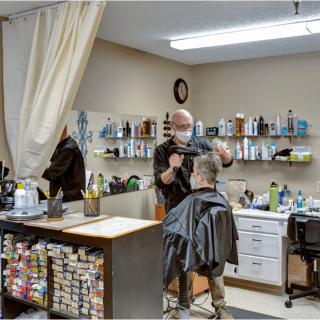 A barber giving a haircut to a customer in a salon.
