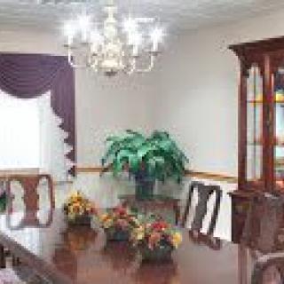 A classic dining room with a wooden table, elegant chairs, and a chandelier.