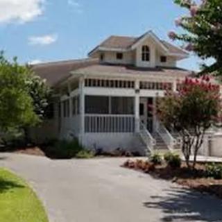 A charming house with a welcoming porch and landscaped surroundings.