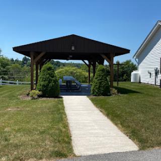 A sunny view of a pavilion with a well-kept lawn and pathway.
