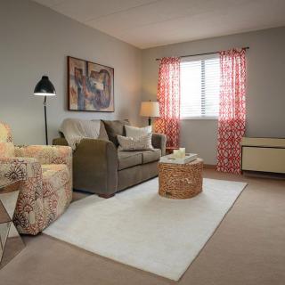 A cozy living room with a sofa, armchair, and warm dcor.