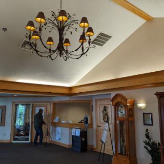 A beautifully designed lobby featuring an elegant chandelier and warm wooden accents.