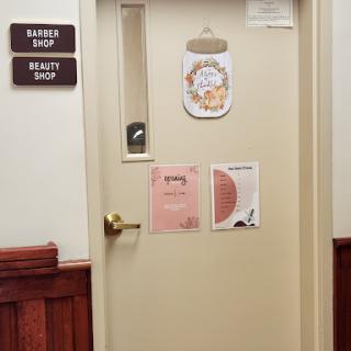 A closed office door with various signs and notices attached.