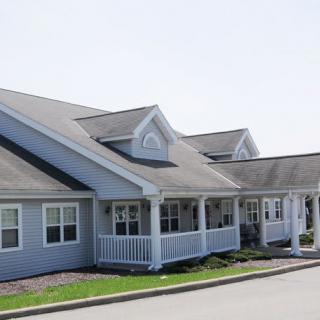 A row of modern residential houses with porches and gabled roofs.