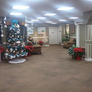A festive lobby decorated for Christmas with a beautifully adorned tree and vibrant poinsettias.