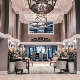 A luxurious hotel lobby with elegant seating and a grand chandelier.