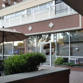 A cozy restaurant with outdoor seating surrounded by greenery.