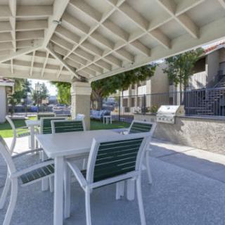 A cozy outdoor seating area with tables and chairs, perfect for gatherings and barbecues.