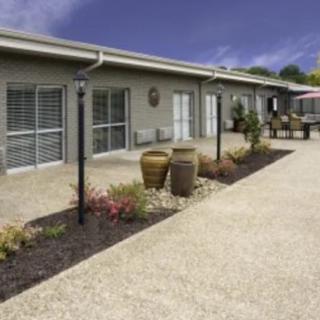 A modern building with a landscaped garden and paved walkway.