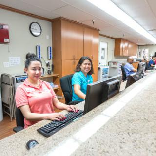 Staff members working at the reception desk in a healthcare facility.