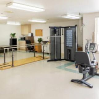 A fitness room with various exercise equipment and rehabilitation tools.