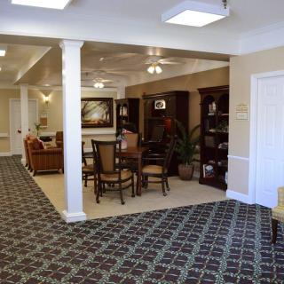 A cozy living room with carpet flooring and comfortable seating areas.