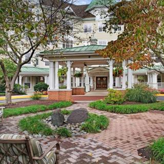 A scenic view of a building entrance surrounded by a well-maintained garden and trees.