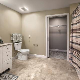 A spacious bathroom with a toilet, sink, and shower area.