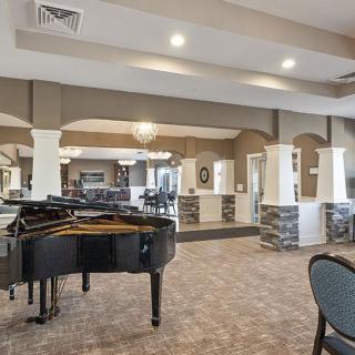 A spacious lounge area featuring a grand piano and stylish decor.