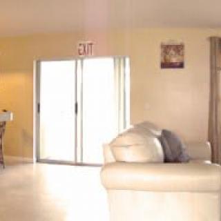 A cozy living room with a sofa and sliding glass door leading outside.