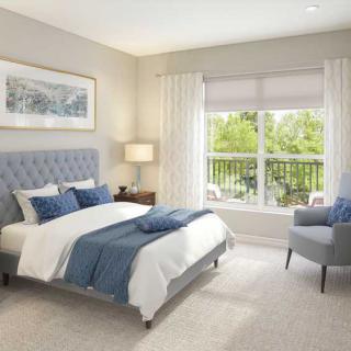 A modern bedroom with neutral tones and blue accents, featuring a large window allowing natural light to fill the room.