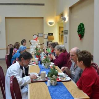 A group of people enjoying a meal together in a communal setting.