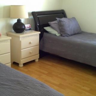 A tidy bedroom with twin beds and a shared nightstand.