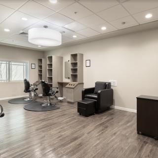 A modern and spacious hair salon with stylish decor and comfortable seating.