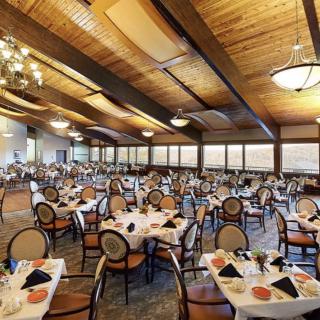 A spacious and elegantly designed dining hall with neatly arranged tables and chairs.