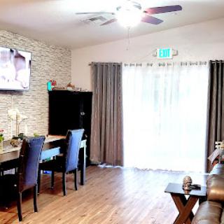 A cozy and modern living room with a dining area, featuring wood flooring and stylish decor.