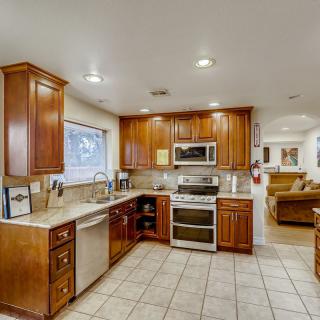 A modern kitchen with wood cabinets and stainless steel appliances.