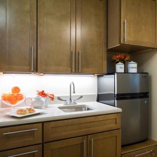 A modern kitchen with wooden cabinets, a stainless steel fridge, and decorative elements.