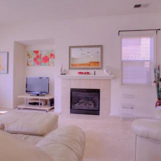 A cozy living room featuring a fireplace, television, and comfortable seating.