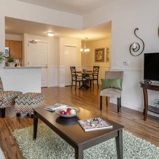 A cozy living room with modern decor, featuring an open floor plan connecting to the dining area.