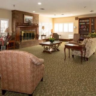 A cozy living room with a fireplace, comfortable seating, and a bookshelf.