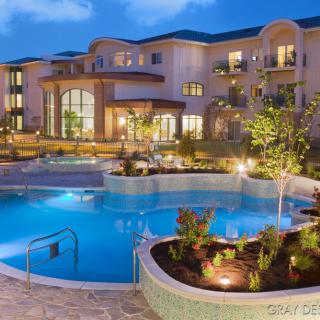 A luxurious resort with a beautifully illuminated swimming pool in the evening.